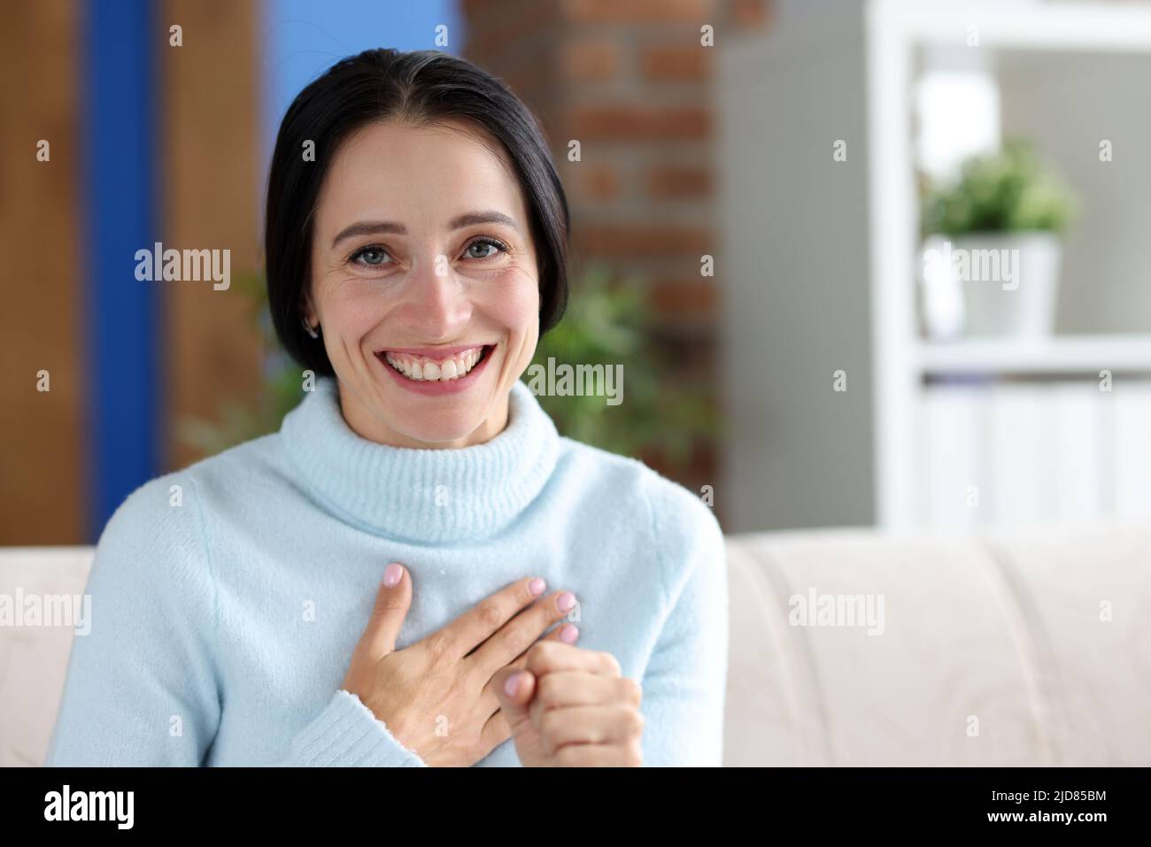 Donna sorridente che guarda la macchina fotografica con felicità Foto Stock