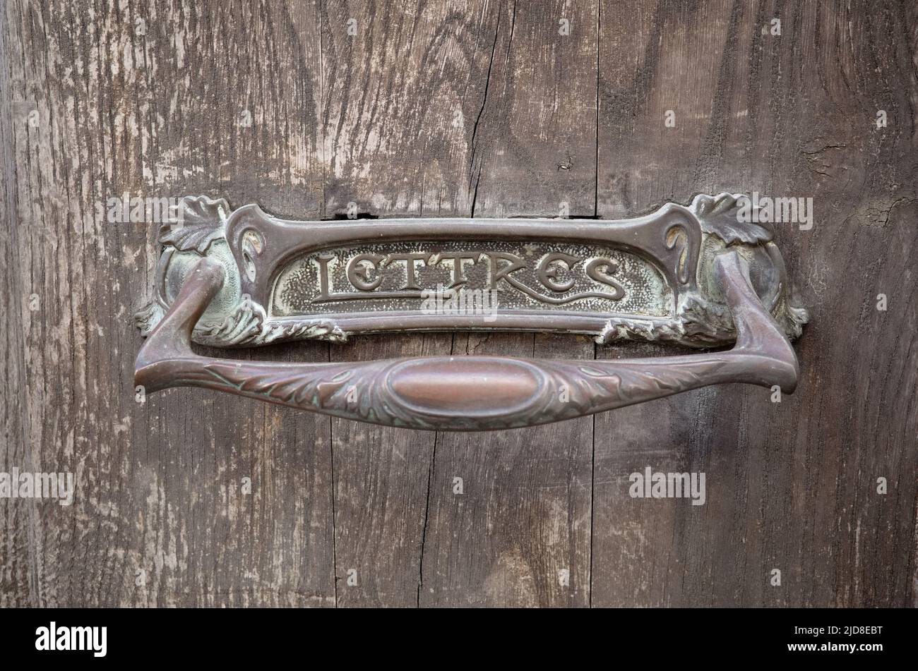 Foro in metallo forgiato per posta con iscrizione Lettres che significa lettere in francese. Vecchio slot di ferro per la posta su legno duro porta resistente agli agenti atmosferici primo piano Foto Stock