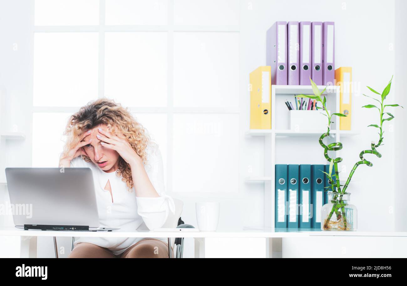 Donna d'affari stanca e addormentata alla scrivania con un computer portatile. Lavoratore in ufficio stanco. Foto Stock