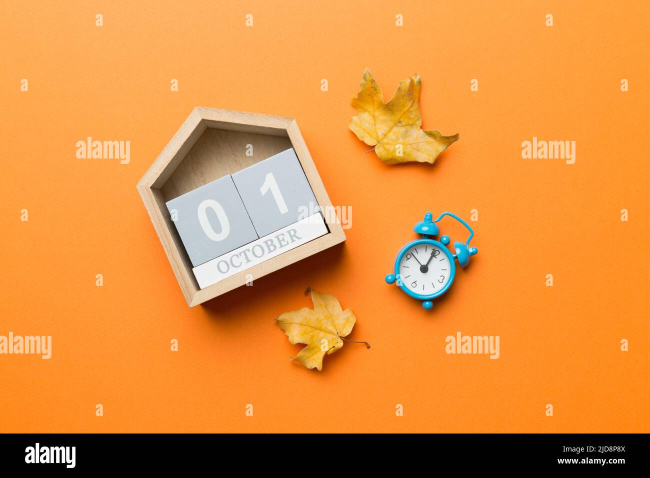 Blocco di calendario in legno con data 1 ottobre con caduta autunno foglie sfondo. Foto Stock