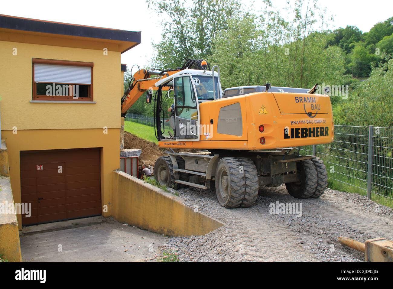 Scavatore scavs molto vicino ad una parete della casa Foto Stock