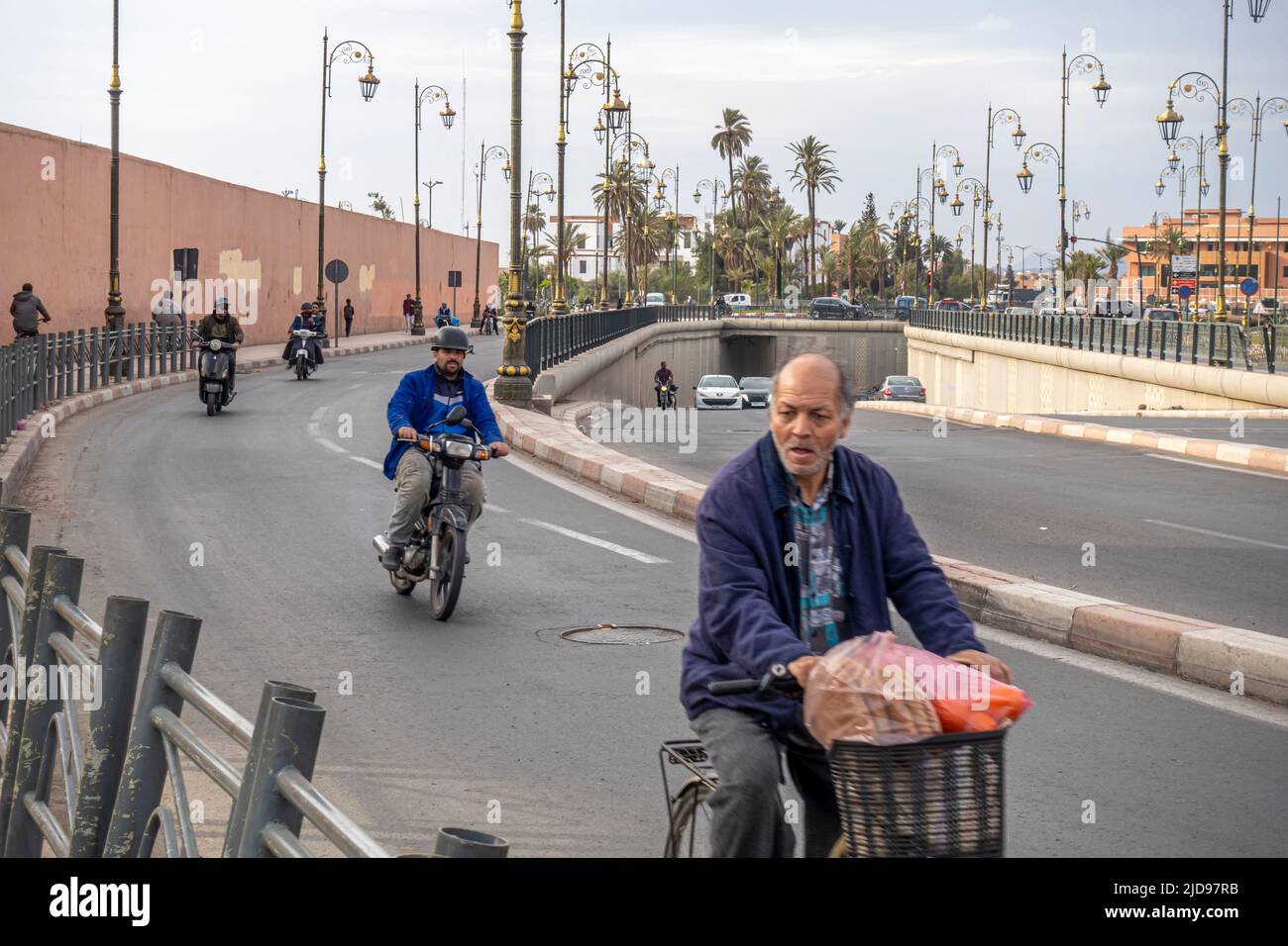 uomo in bicicletta su una strada autostradale. Bicicletta tra le motociclette. Marrakech, Marocco Foto Stock