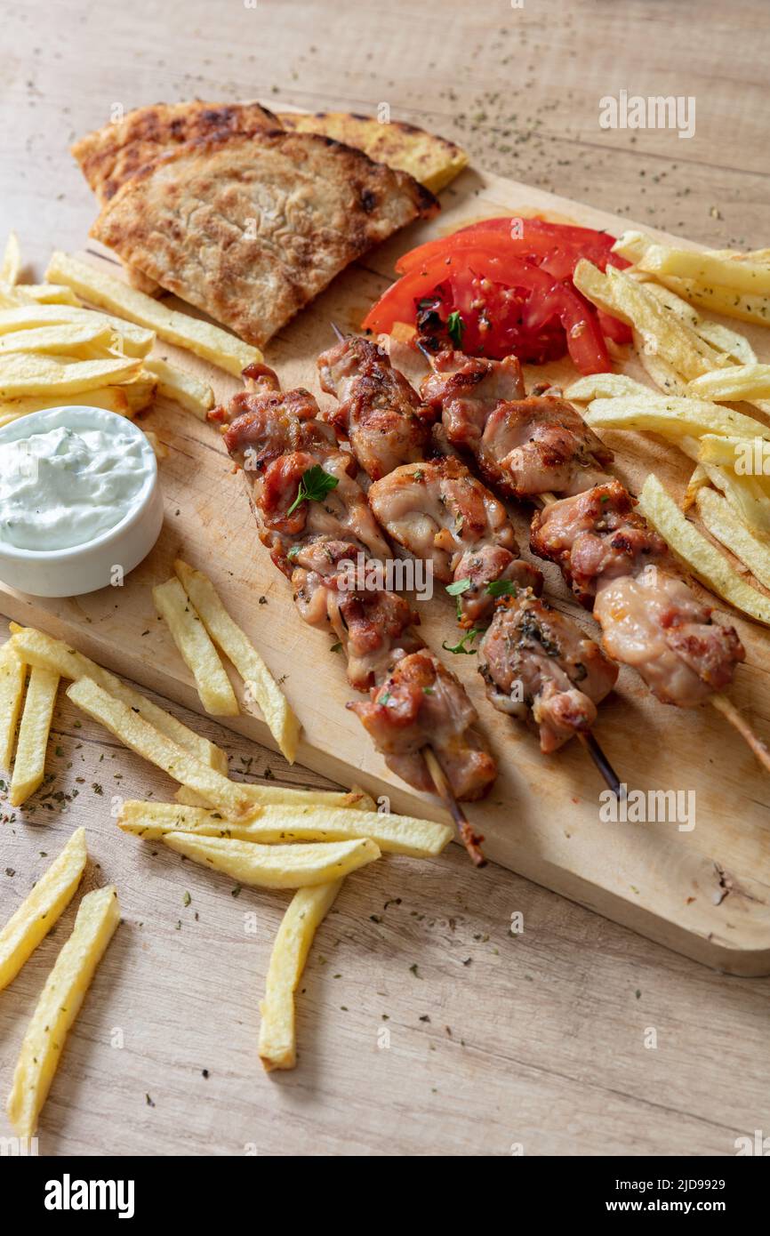 Piatto souvlaki, carne di pollo greco. Spiedini alla griglia e pita pane su tavola di legno, da vicino sopra vista, Foto Stock
