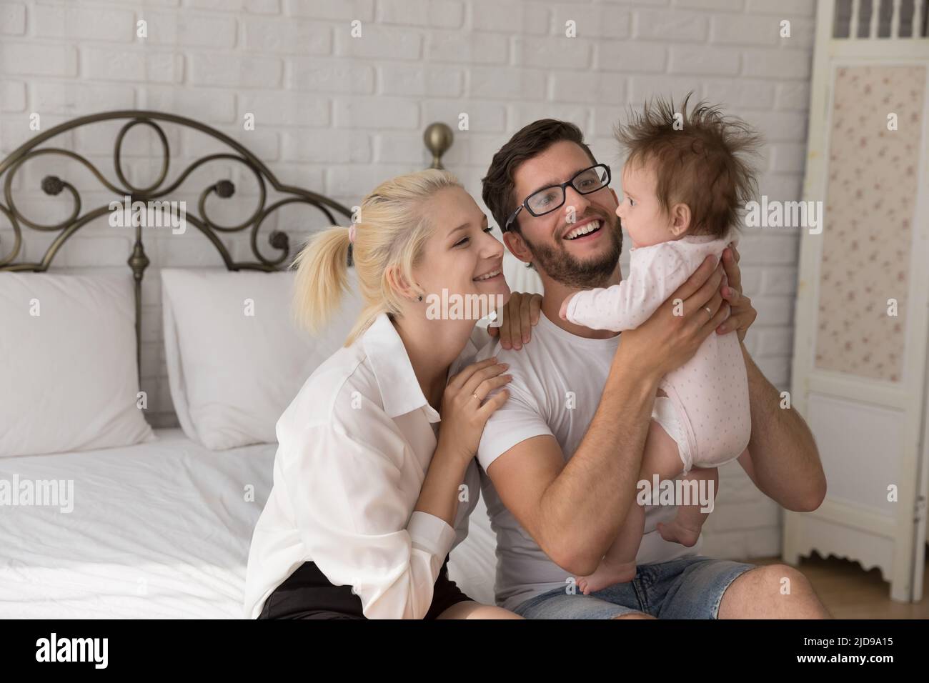 I giovani genitori felici trascorrono il tempo con il bambino a casa Foto Stock