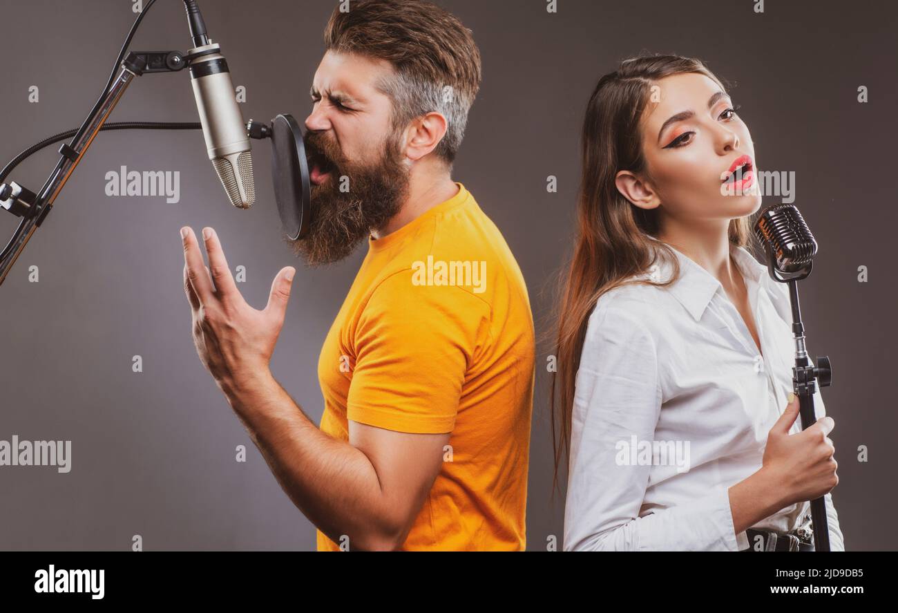 Il duetto cantante sta eseguendo una canzone con un microfono durante la registrazione in uno studio musicale. Foto Stock