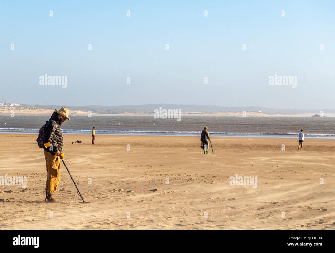 Un uomo sta rilevando il ferro con un metal detector multifrequenza sulla spiaggia di Essaouira, Marocco Foto Stock