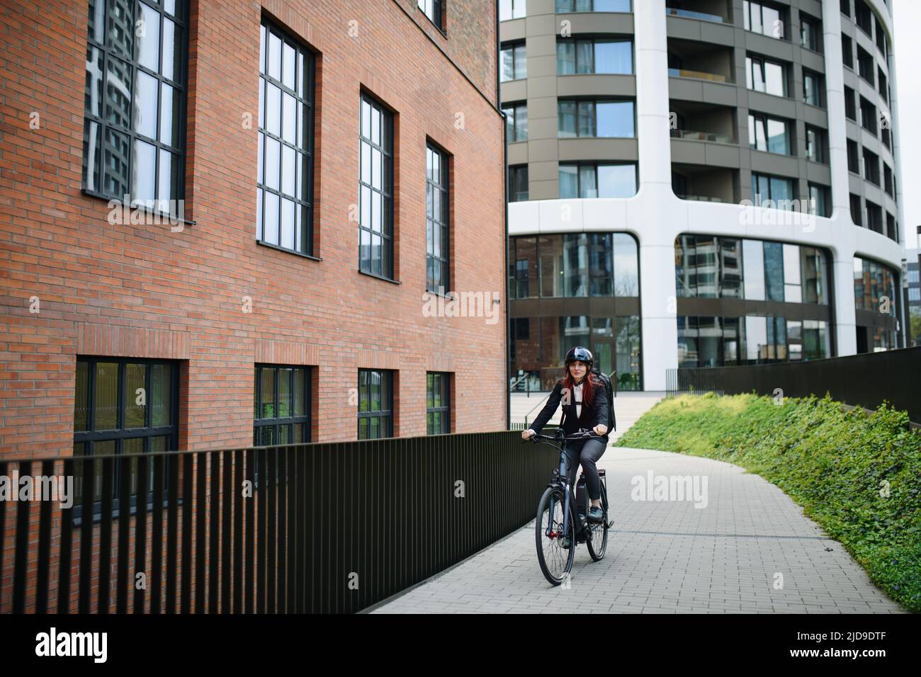Business woman commuter sulla strada per lavorare in bicicletta, concetto di stile di vita sostenibile. Foto Stock