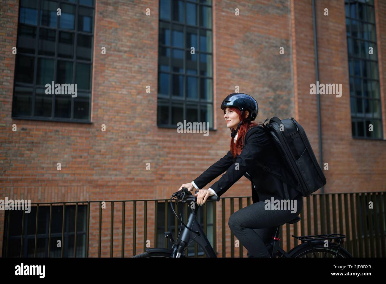 Business woman commuter sulla strada per lavorare in bicicletta, concetto di stile di vita sostenibile. Foto Stock