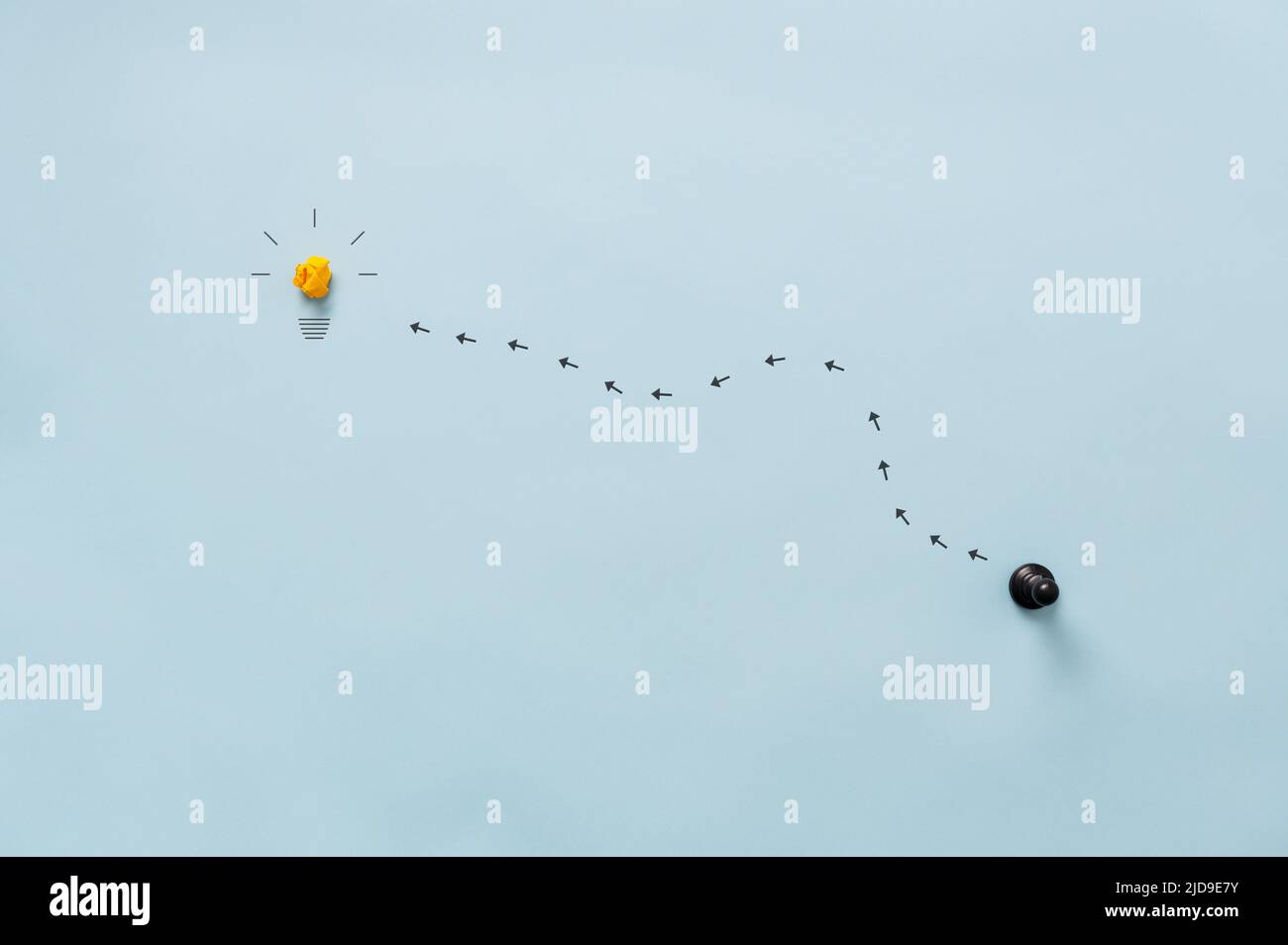 Frecce che conducono verso una lampadina da una figura di pedina nera in un'immagine concettuale di business e personale sviluppo e idea. Su blu Foto Stock