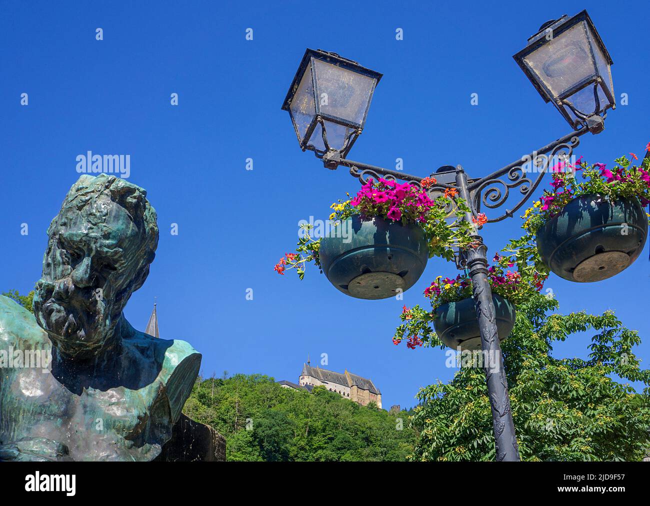 Vista dal nostro ponte fino al castello, busto di Victor Hugo e vecchia lampada di strada, Vianden villaggio, cantone di Vianden, Lussemburgo, Europa Foto Stock