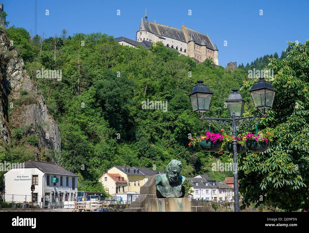 Vista dal nostro ponte fino al castello, busto di Victor Hugo e vecchia lampada di strada, Vianden villaggio, cantone di Vianden, Lussemburgo, Europa Foto Stock
