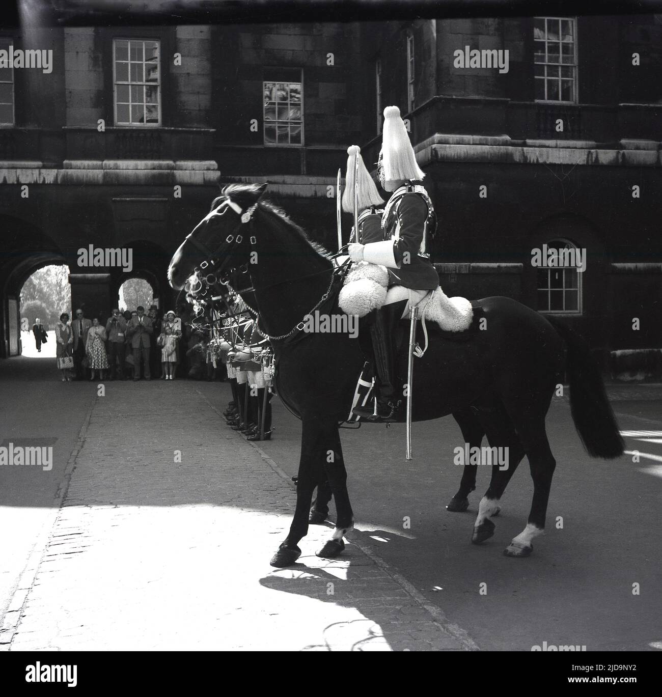 1958, storici, spettatori che guardano le guardie reali della cavalleria domestica della Regina sui loro cavalli alla parata cerimoniale a Horse Guards, Whitehall, Londra, Inghilterra, Regno Unito. Foto Stock
