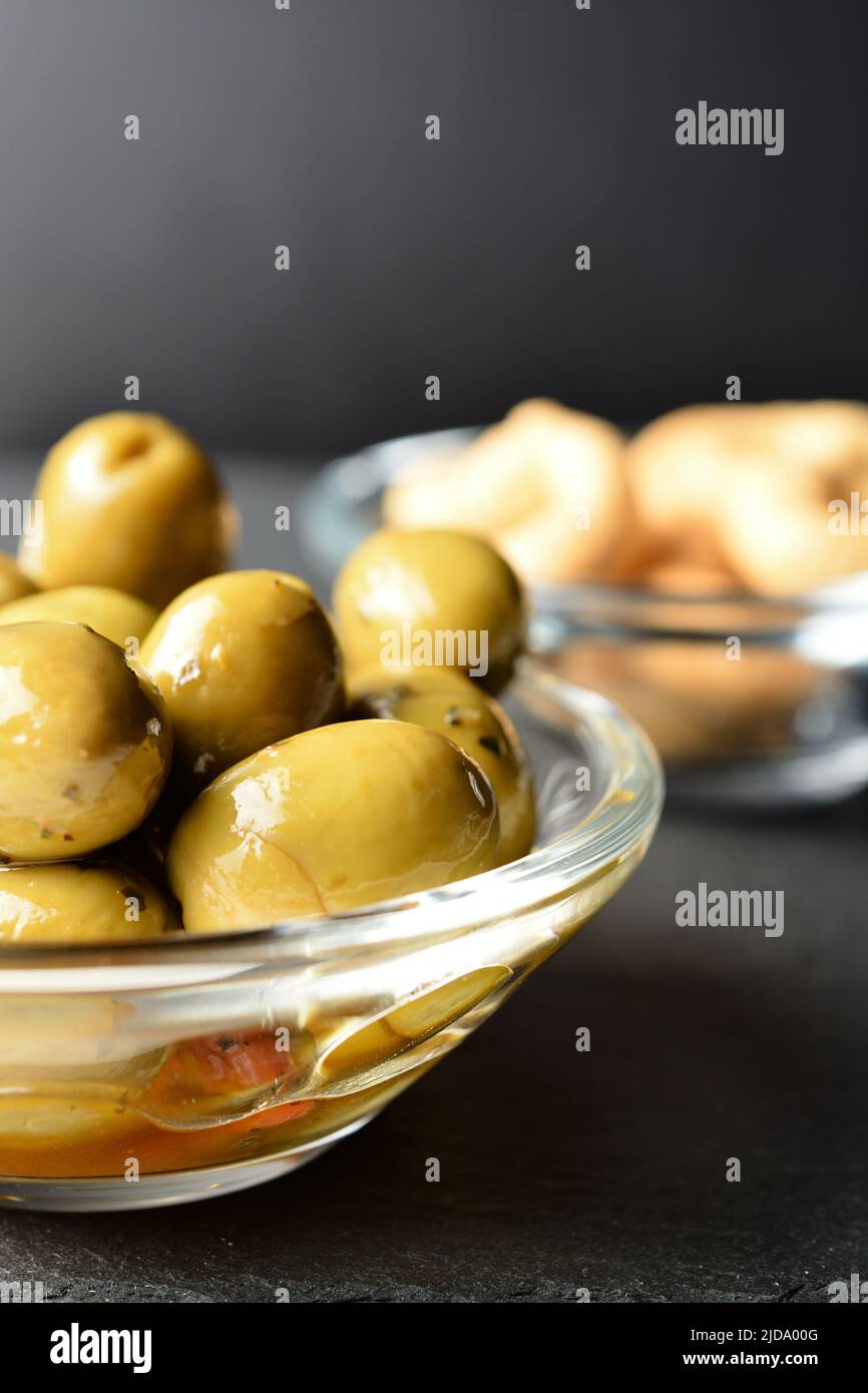 Condite olive verdi in una ciotola. Foto Stock