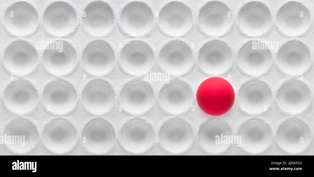 Un uovo rosso in un fumetto bianco vuoto. ( Fuoco selettivo ) concetto di differenza e solitudine. Foto Stock