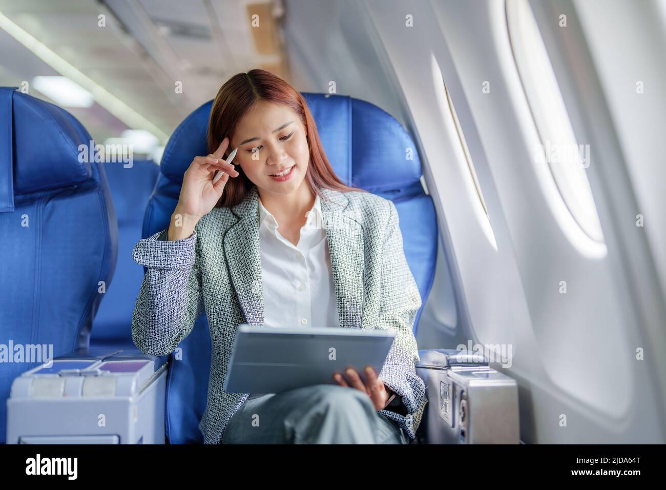 Viaggio, Ritratto di una donna d'affari asiatica che utilizza un tablet per pianificare mentre si è in aereo tra l'attesa di negoziare affari con stranieri Foto Stock