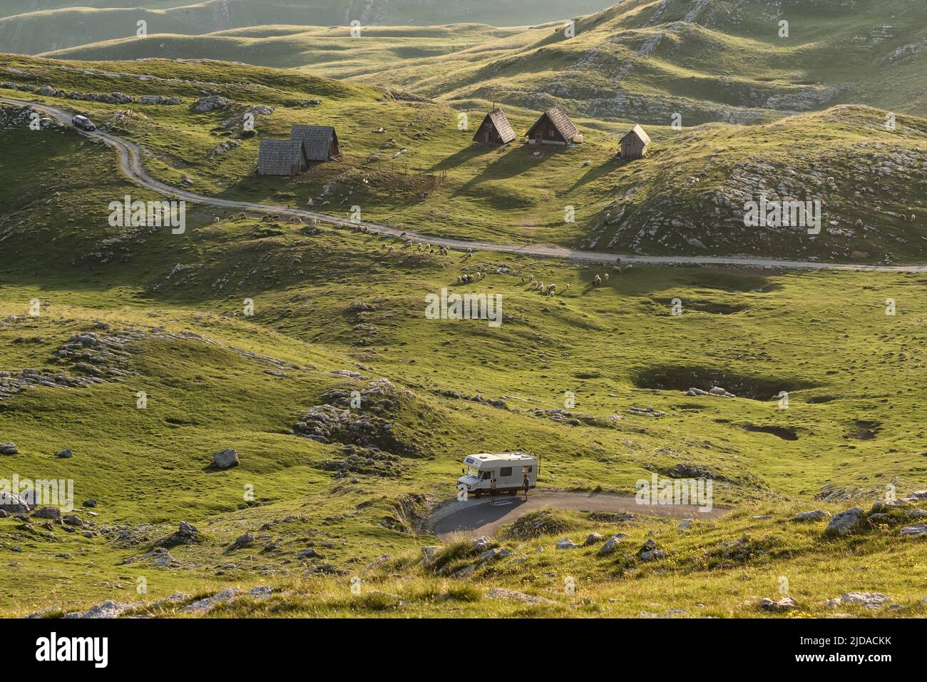 Paesaggio con case di pastore, gregge di pecore e camper in Montenegro. Foto Stock