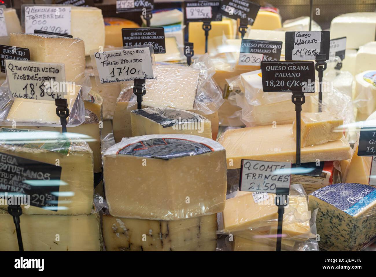 Diversi tipi di formaggi in una gastronomia con insegne in spagnolo. Foto Stock