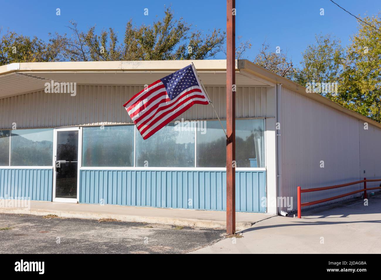 Bandiera americana che vola fuori da un edificio su una strada principale. Foto Stock