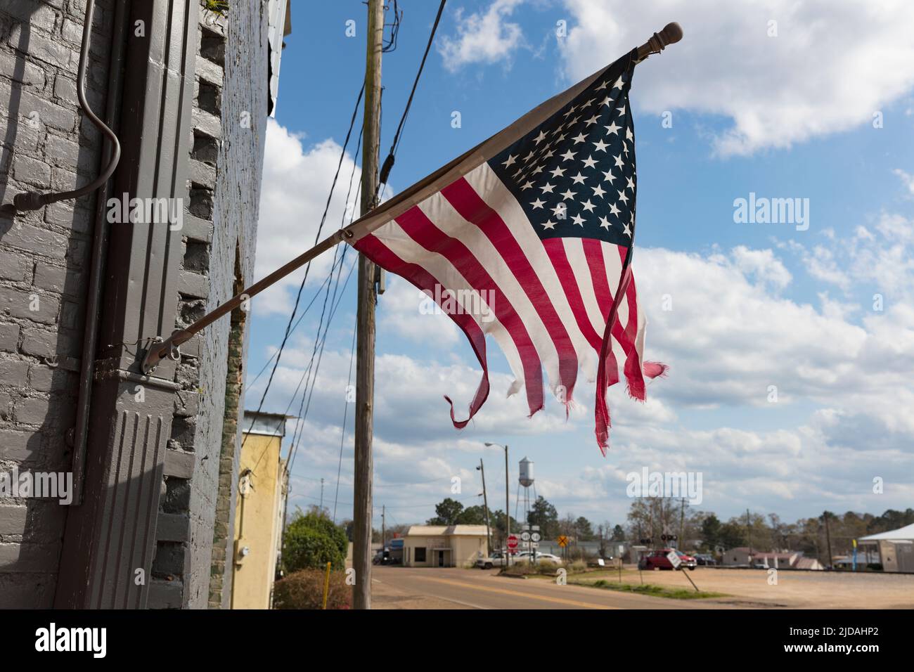 Bandiera americana Tattered che vola su un edificio in Main Street. Foto Stock
