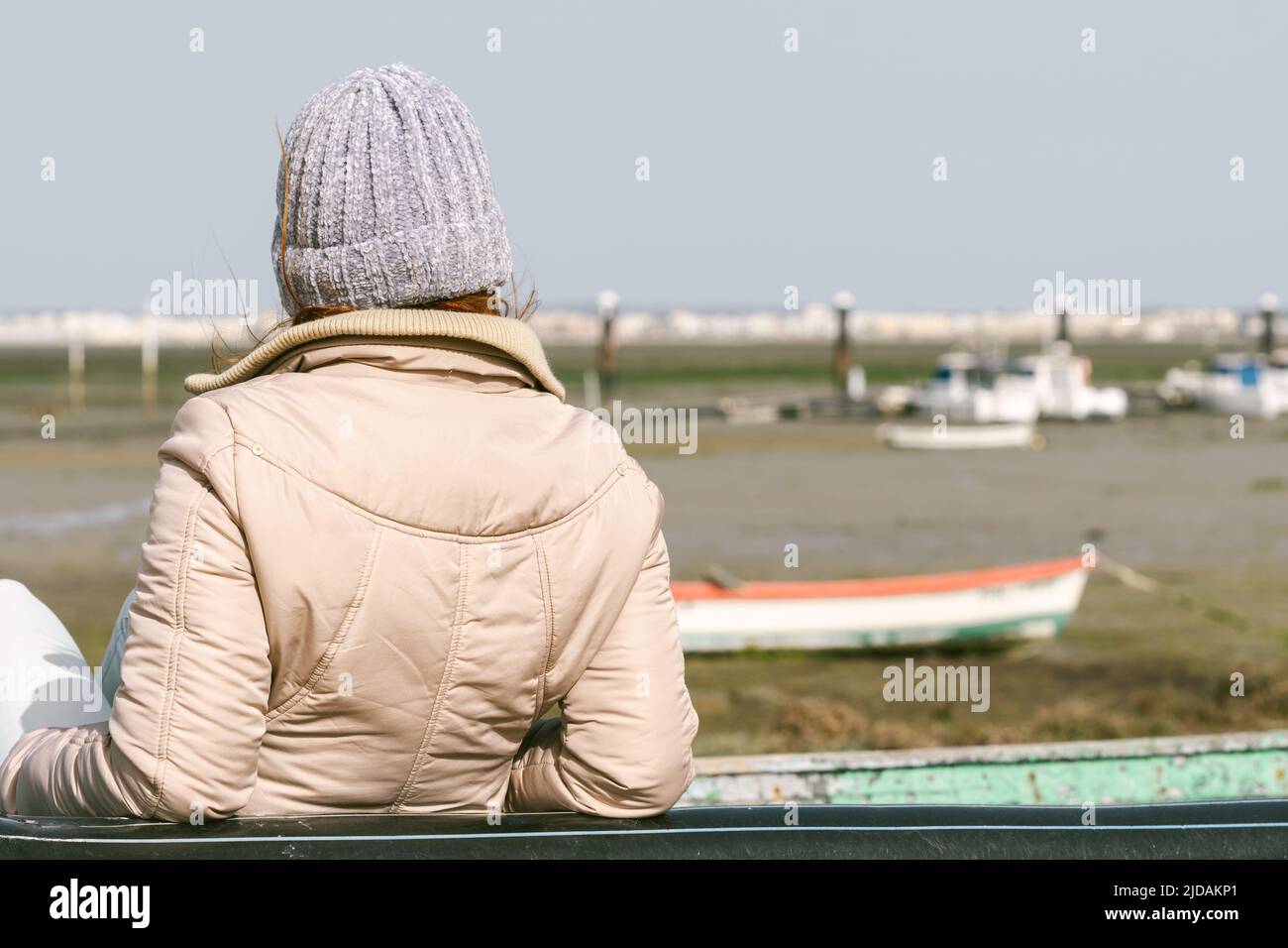 donna sulla schiena appoggiata contro una barca da pesca Foto Stock