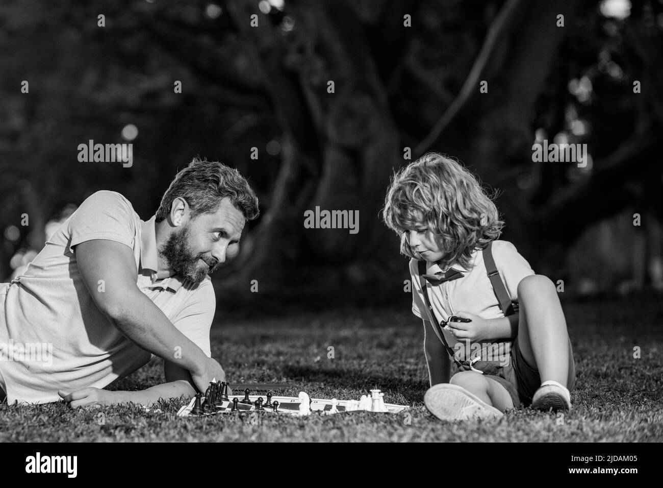 Sonplaying scacchi con padre. Bambino che gioca a bordo con il genitore. Foto Stock