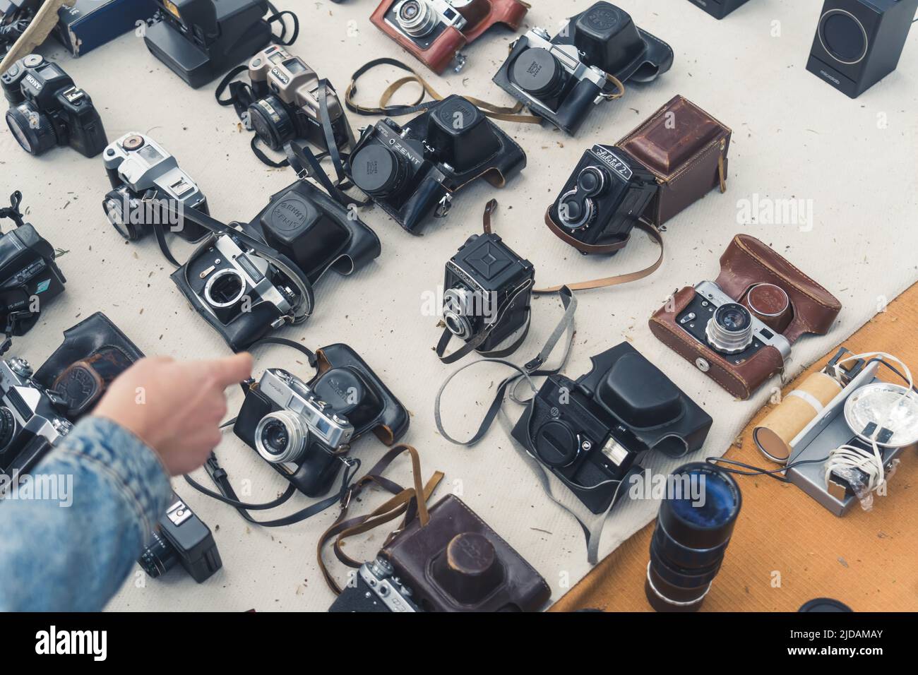 18.05.2022. Tbilisi, Georgia. Cliente che fa una scelta tra vecchie telecamere retrò sul mercato delle pulci. Foto di alta qualità Foto Stock