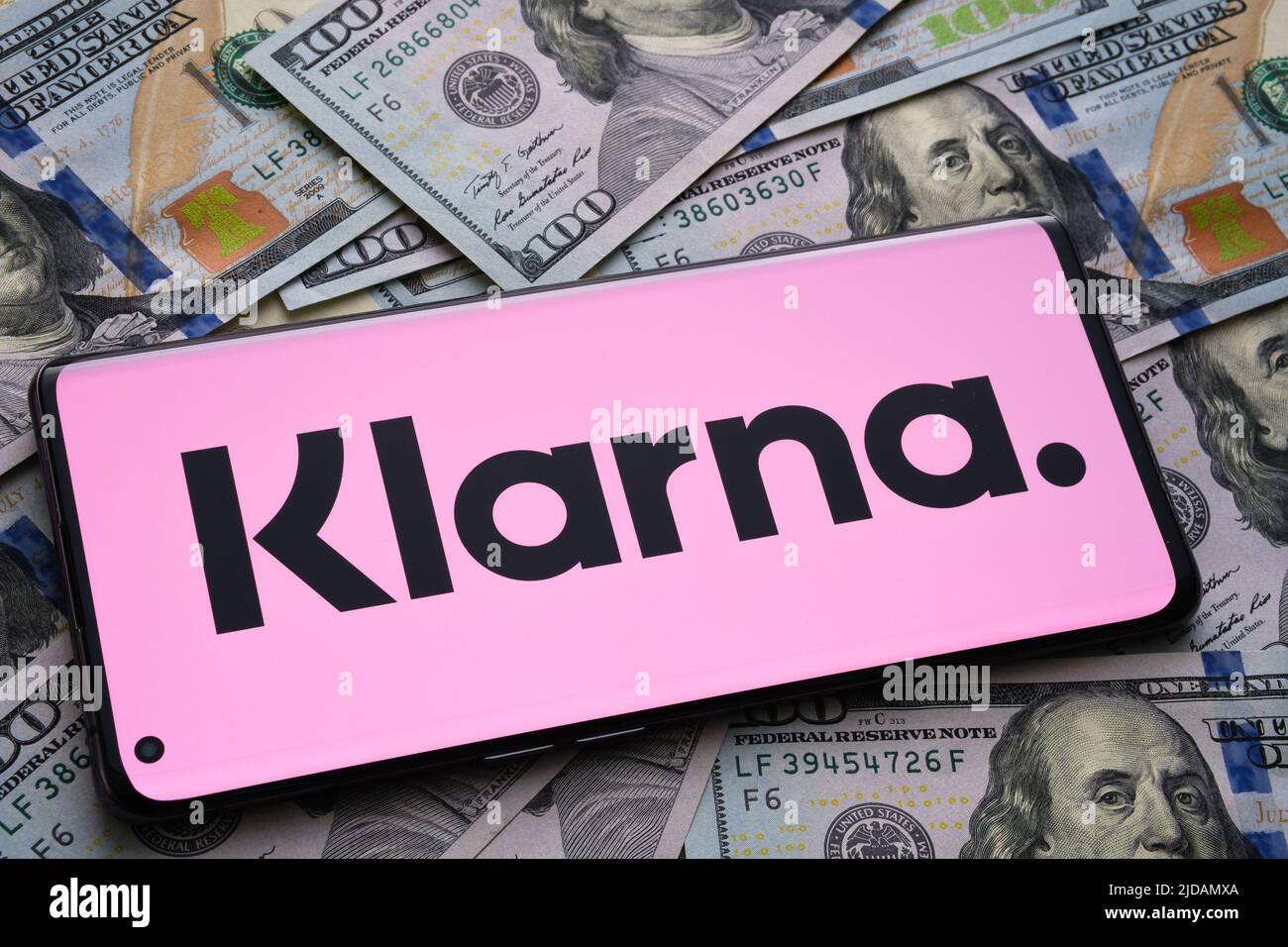 Logo dell'app Klarna visto sullo schermo dello smartphone piazzato su bollette in dollari. Concetto per l'app di credito. Stafford, Regno Unito, giugno 19 2022 Foto Stock