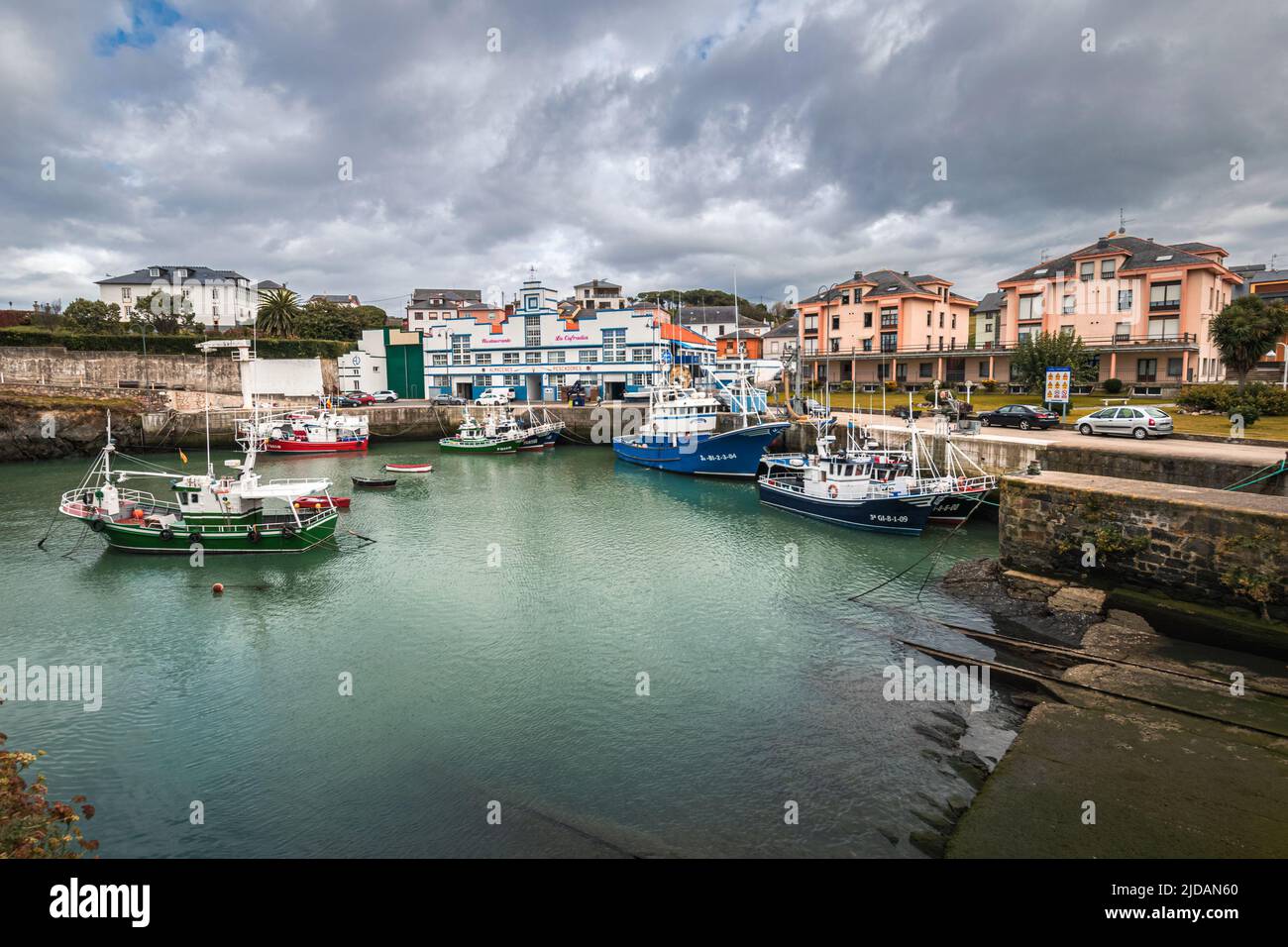 Pittoresca zona portuale della città di Puerto de Vega nelle Asturie, in Spagna, con belle acque blu e barche da pesca. Foto Stock