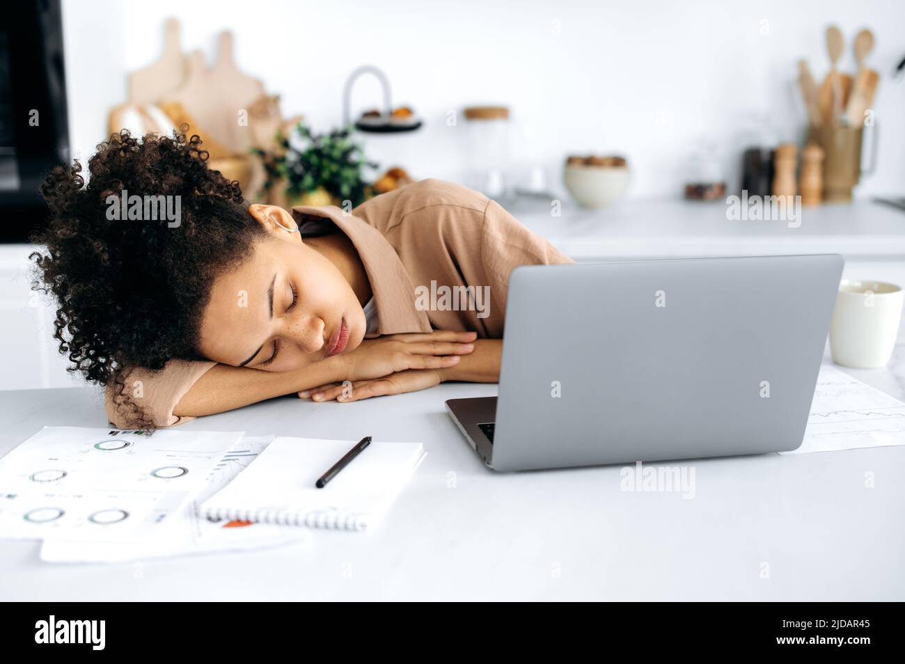 Privazione cronica del sonno. Esausta ragazza afroamericana, ragazza freelance o studente, si è addormentato al desktop vicino al laptop, ha lavorato troppo dal lavoro o dallo studio online, ha bisogno di riposo e sonno Foto Stock