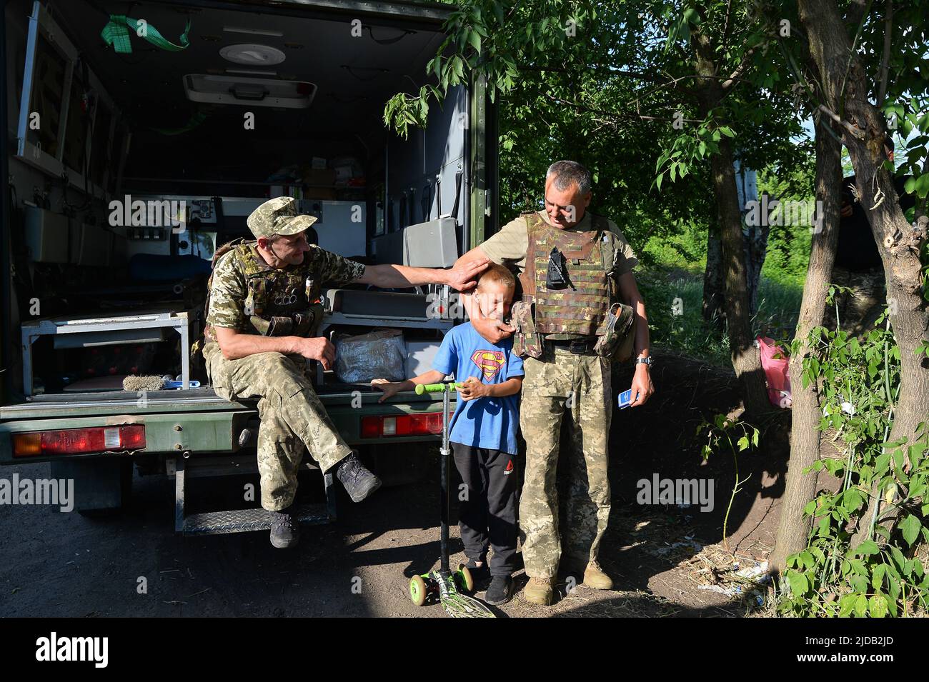 Lysychansk, Ucraina. 19th giugno 2022. Fuori da Lysychansk, i medici aspettano la loro prossima evacuazione dei feriti. I bambini dei villaggi circostanti aiutano a passare il tempo con i medici. Credit: SOPA Images Limited/Alamy Live News Foto Stock