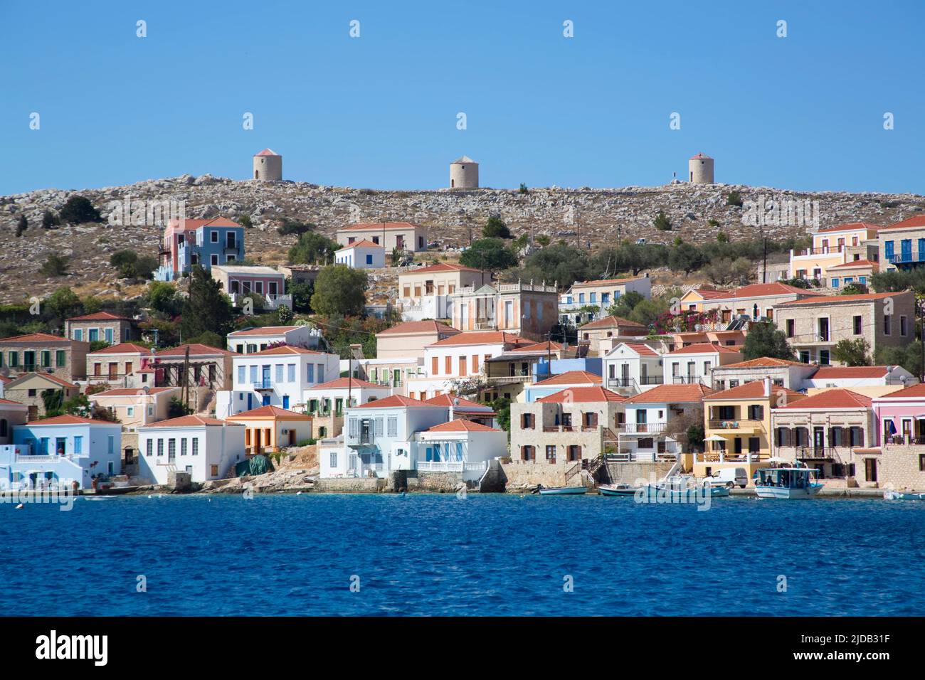 Edifici tradizionali lungo il lungomare nel porto di Emborio, la città principale sull'isola di Halki (Chalki); gruppo di isole Dodecanesi, Grecia Foto Stock