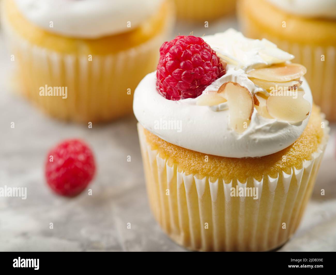 Dessert leggero e delizioso - muffin con crema proteica, lamponi e mandorle su sfondo bianco. Primo piano. Ristorante, hotel, panetteria, supermercato. Foto Stock