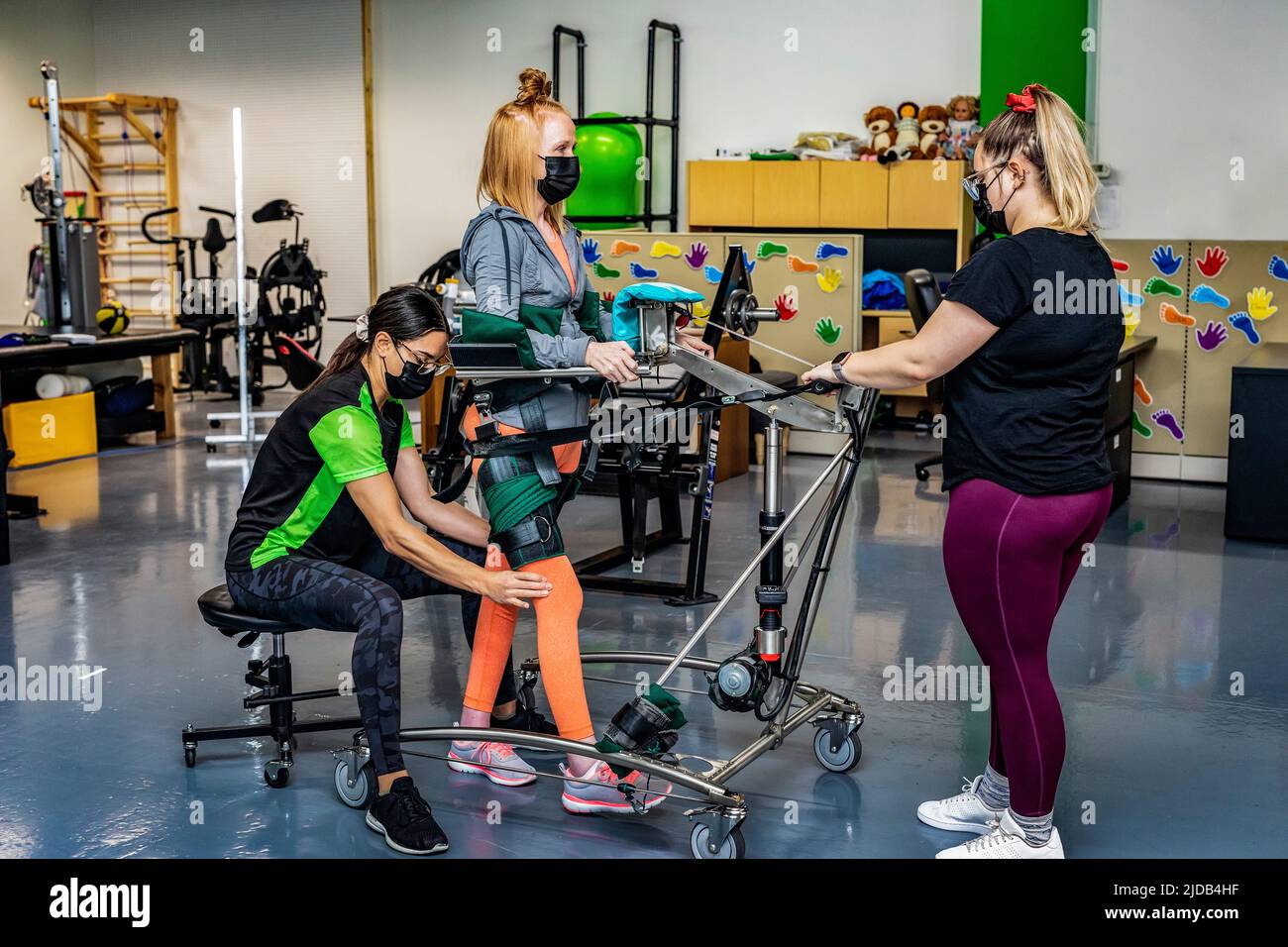 Una donna paraplegica che si allenava con una macchina da camminata assistita con i suoi allenatori; Edmonton, Alberta, Canada Foto Stock