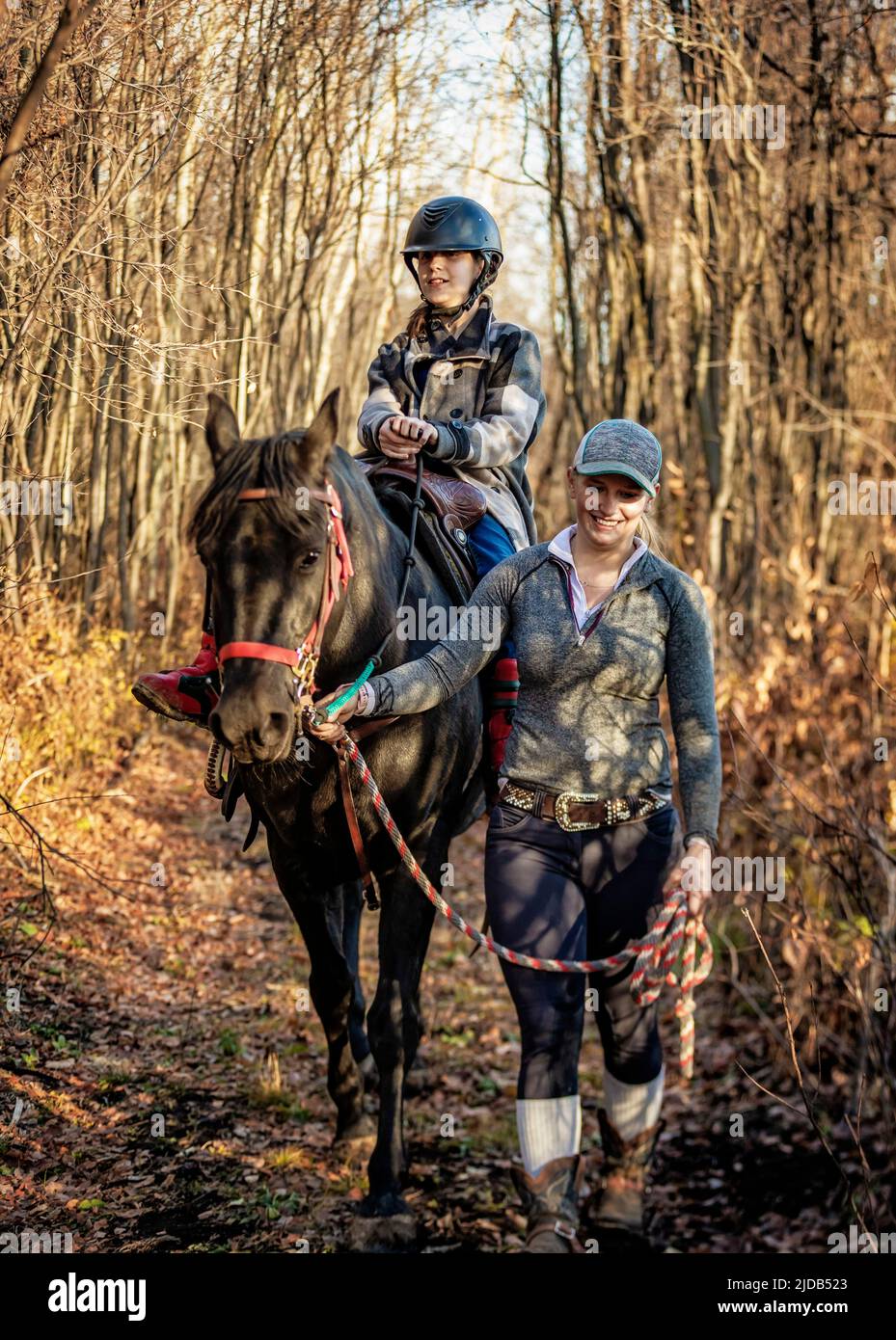 Una giovane ragazza con Cerebral Palsy e il suo allenatore che lavora con un cavallo su un sentiero durante una sessione di ippoterapia; Westlock, Alberta, Canada Foto Stock