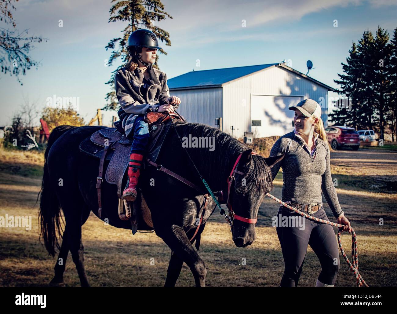 Una giovane ragazza con la paralisi cerebrale e il suo allenatore che lavora con un cavallo durante una sessione di ippoterapia; Westlock, Alberta, Canada Foto Stock