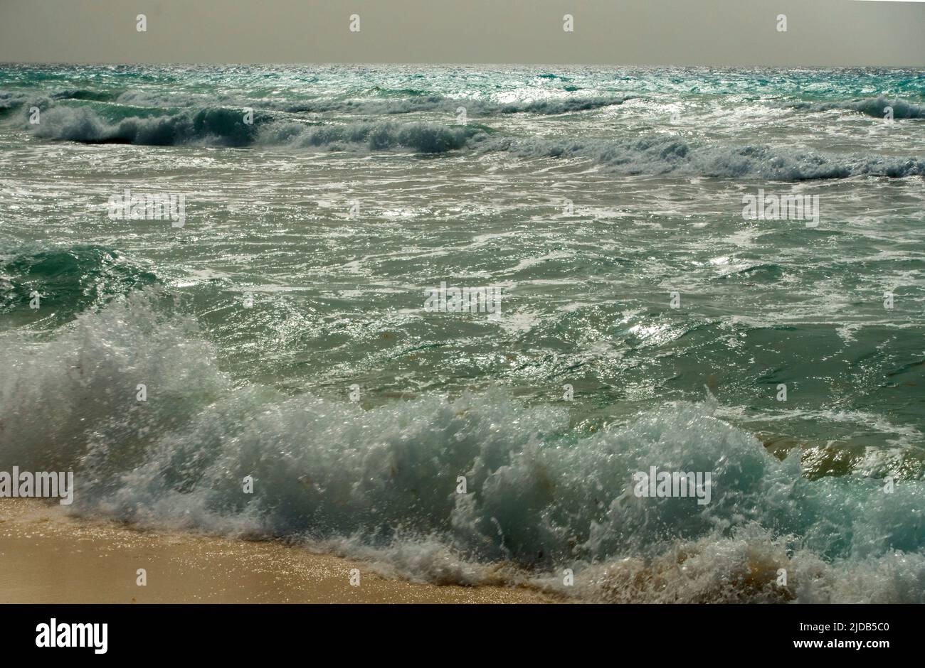 Le onde di mare si infrangono sulla spiaggia Foto Stock