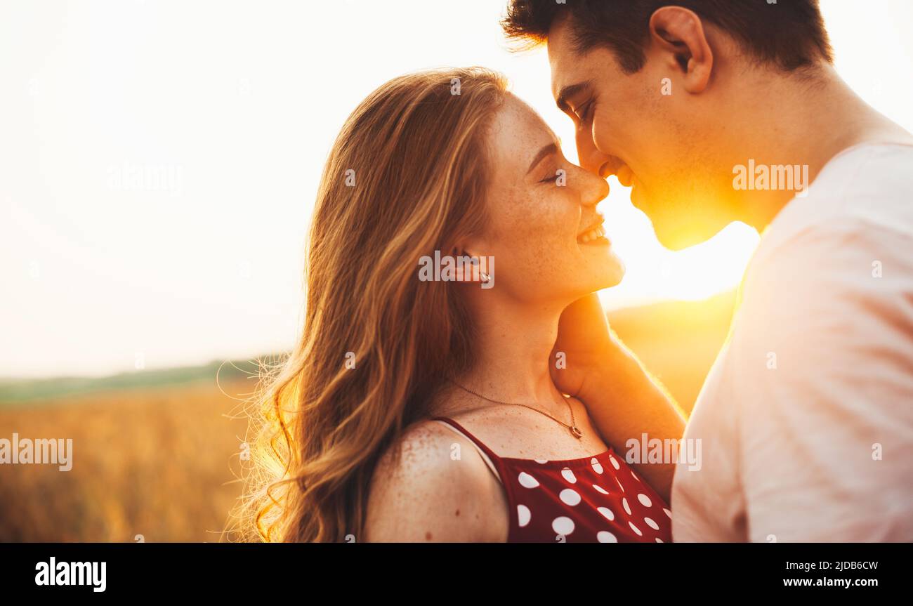 Ritratto di attraente coppia caucasica in amore baciare in estate in campo. Romantica coppia datazione. Amore, datazione. Ritratto di bellezza femminile. Foto Stock