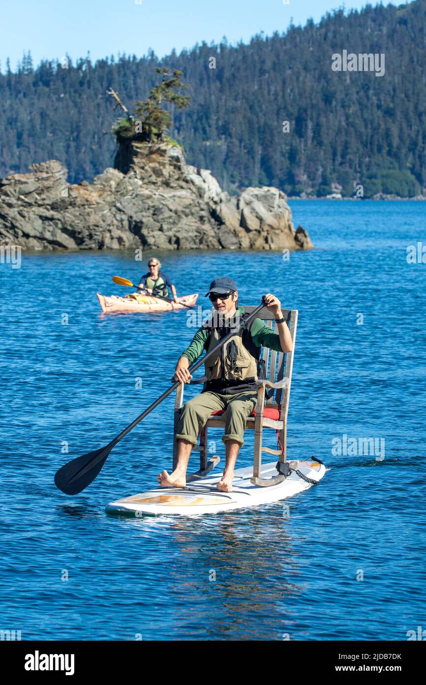 La guida di Tutka Bay Lodge ha indossato una sedia a dondolo sulla sua tavola da surf in piedi per trasformarla in una tavola da sedersi Foto Stock