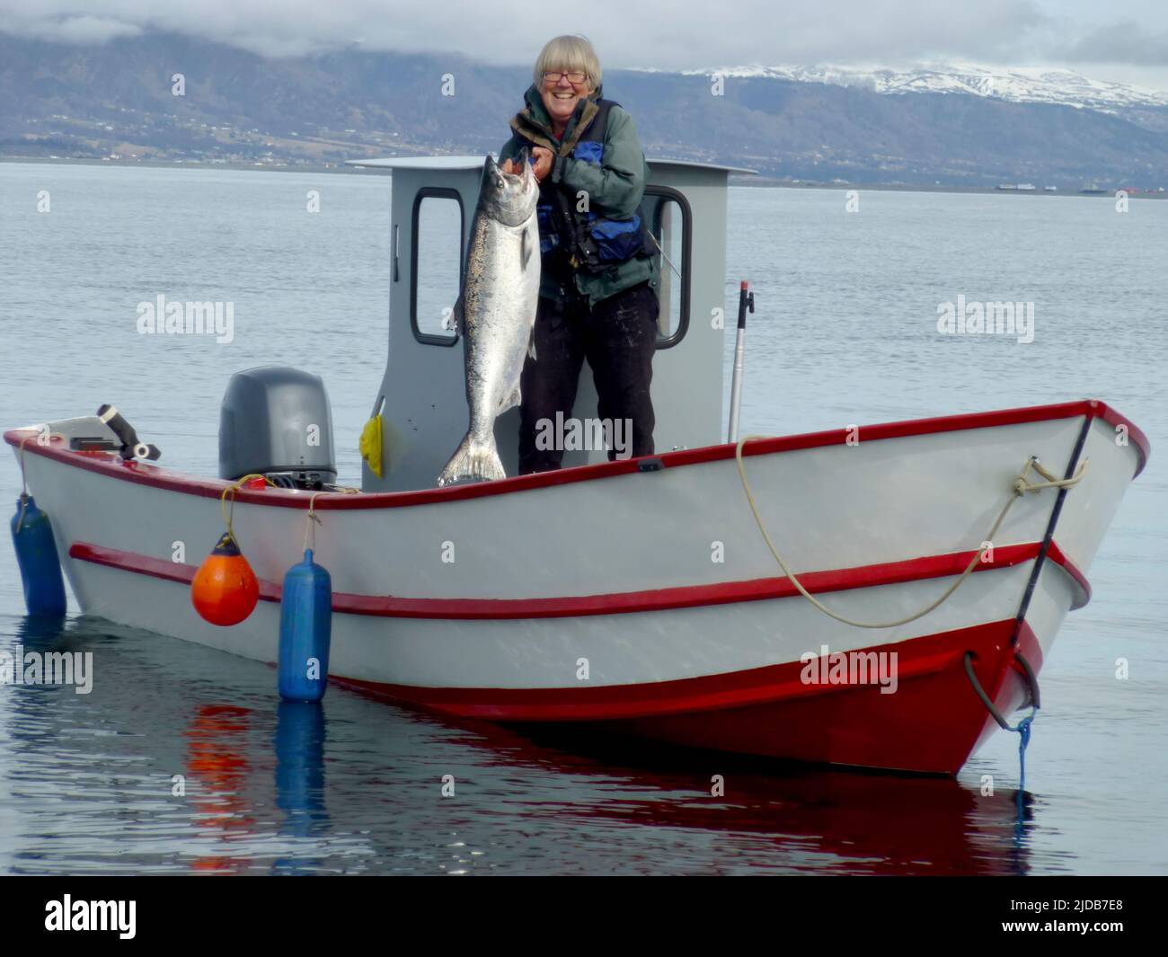 La residente di lunga data di Homer mostra il salmone reale di 30 kg catturato mentre traina per il salmone nella baia di Kachemak, nel suo Tolman Skiff prodotto localmente Foto Stock