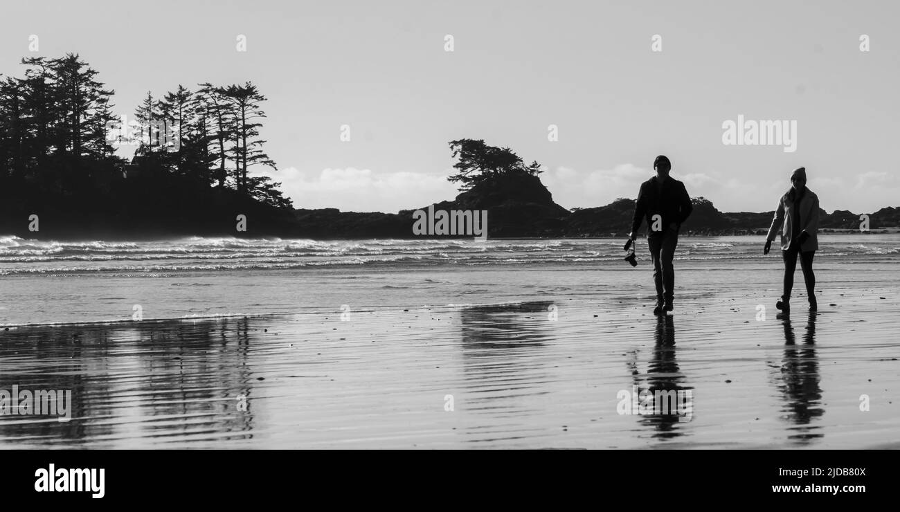 Due persone camminano a Chesterman Beach, Vancouver Island; British Columbia, Canada Foto Stock