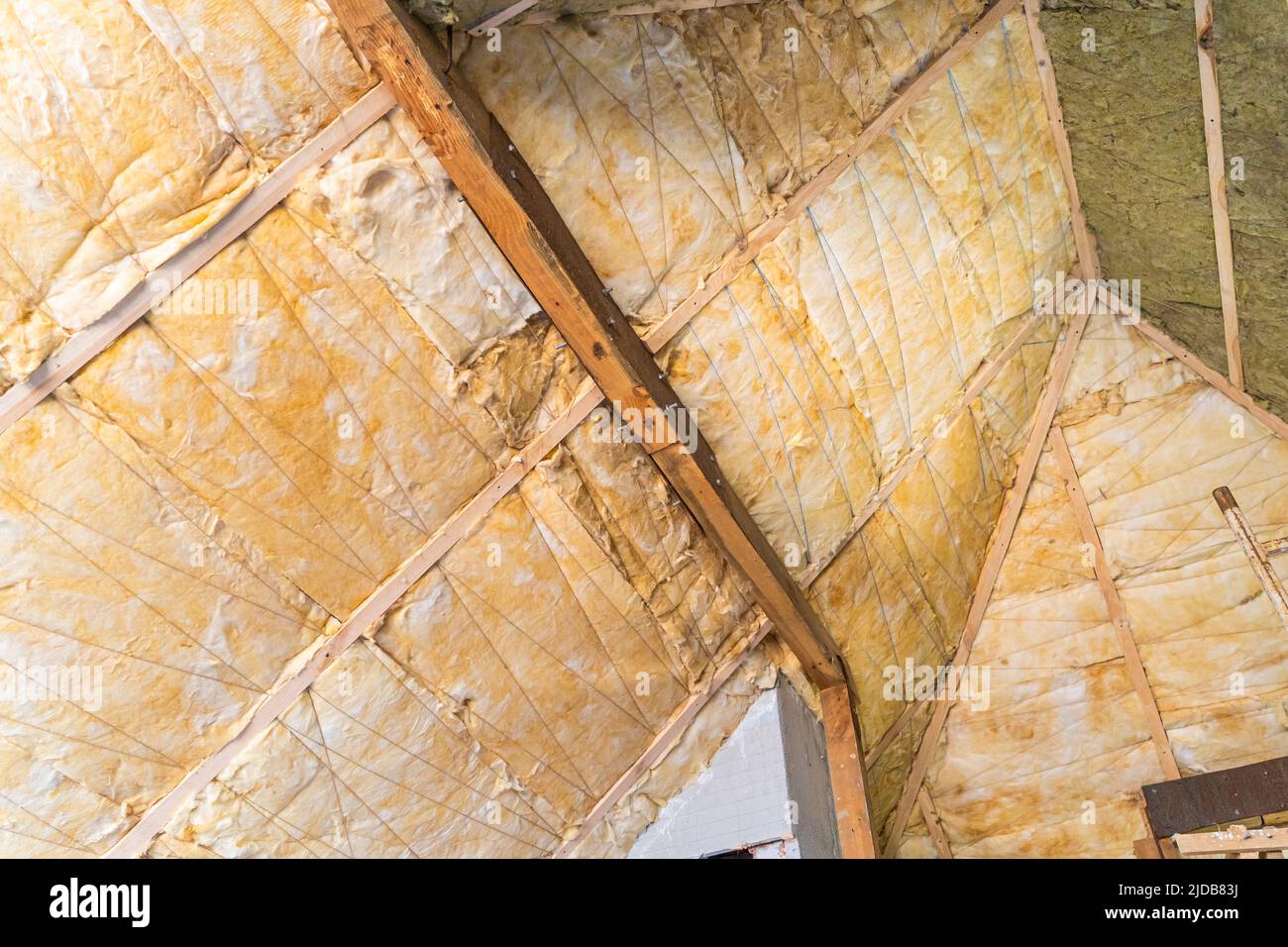 Il tetto è isolato con il primo strato di lana di vetro gialla Foto Stock