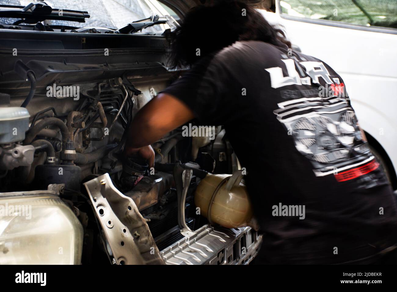 Il meccanico tailandese e tecnico professionale di riparazione e manutenzione del motore di automobile controlla la disponibilità e prepara il motore di servizio di riparazione dell'automobile alla ga locale Foto Stock