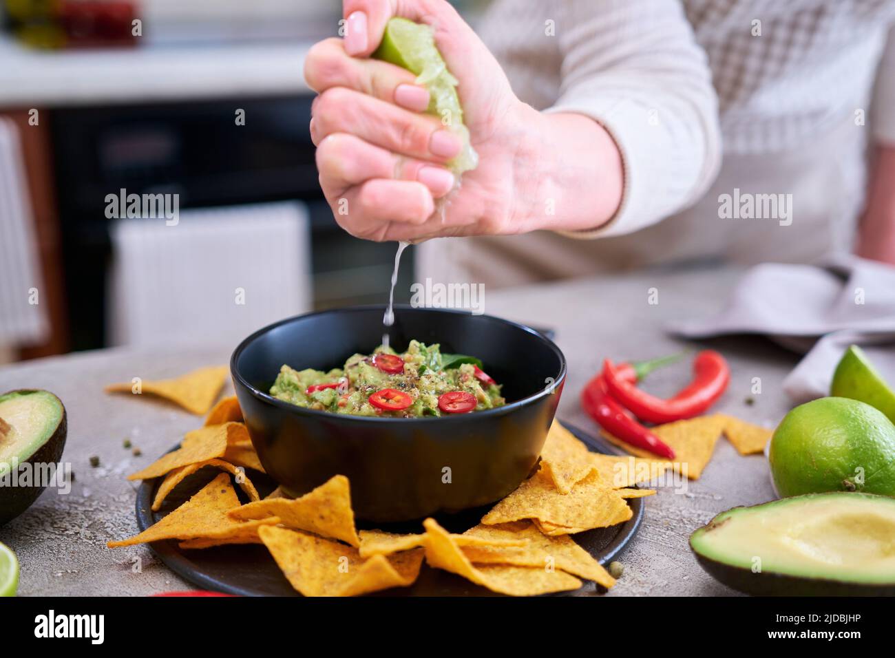 Immersione guacamole con tortilla chips o nachos su tavola nera Foto Stock