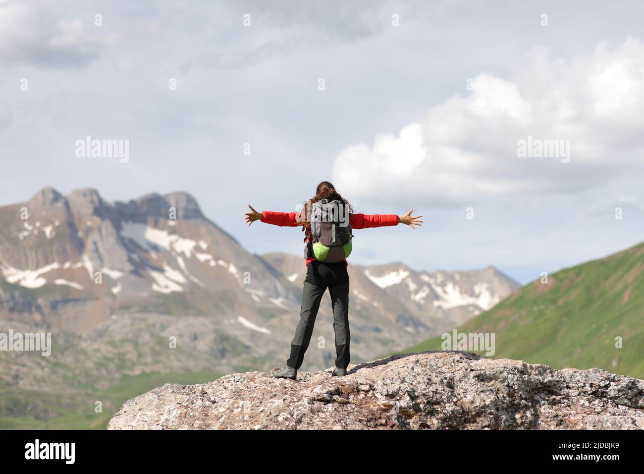 Escursionista che festeggia il successo di stendere le armi in cima ad un'alta montagna Foto Stock