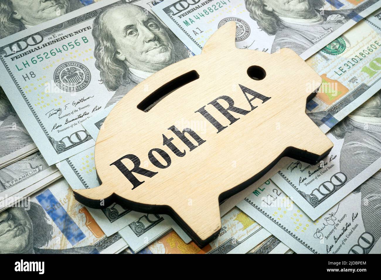Piggy banca con segno Roth IRA su denaro. Foto Stock