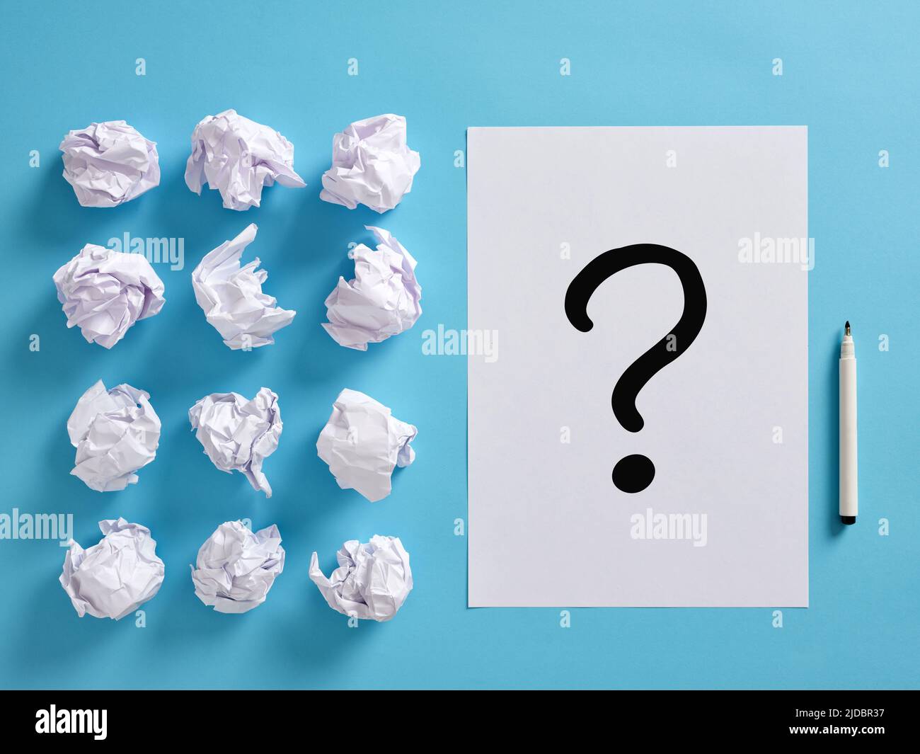 Icona del punto interrogativo su un foglio di carta con sfere di carta arricciate e una penna. Concetto di brainstorming e risoluzione dei problemi. Foto Stock