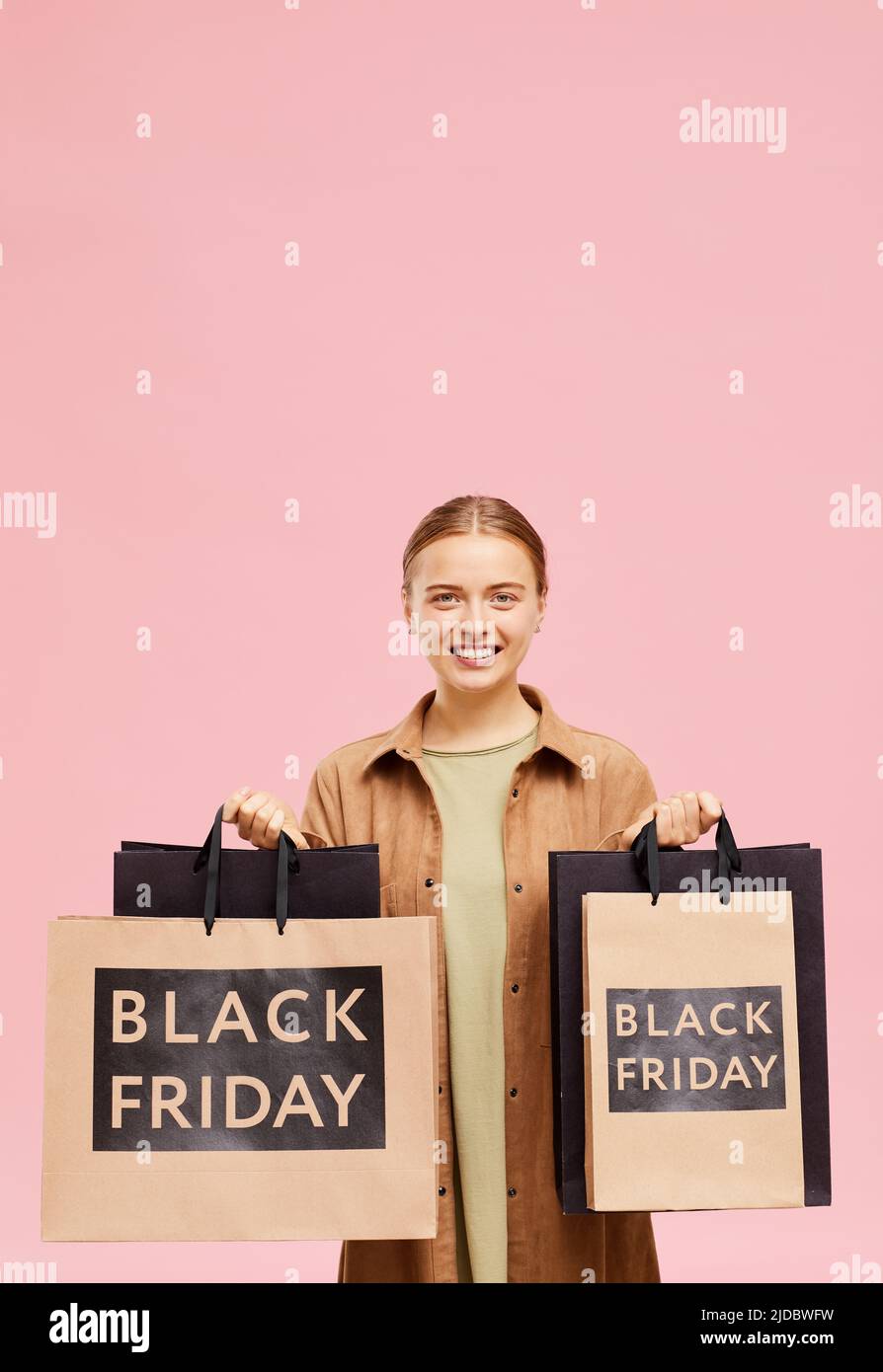 Ritratto di positiva bella giovane donna in camicia lunga vantando con acquisti il Venerdì nero Foto Stock