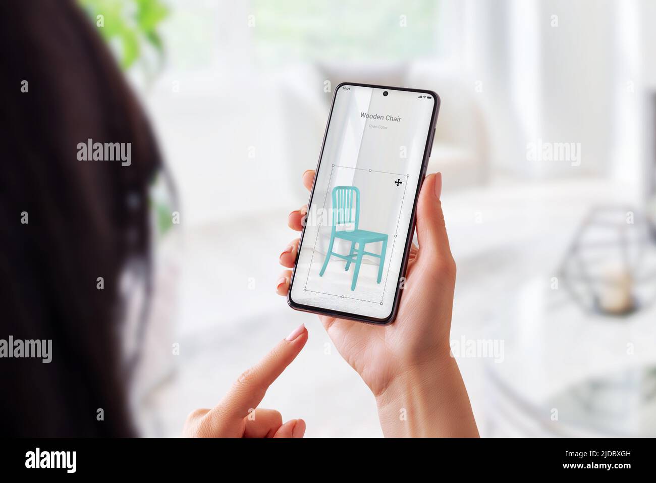 La donna con l'app realtà aumentata imposta una sedia in legno nel salotto. Posizionamento di mobili virtuali con concetto mobile Foto Stock