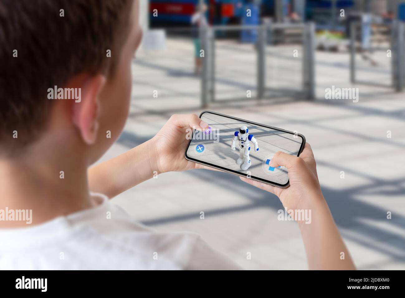 Boy programma e controlla il robot in strada attraverso il concetto di tecnologia della realtà aumentata Foto Stock