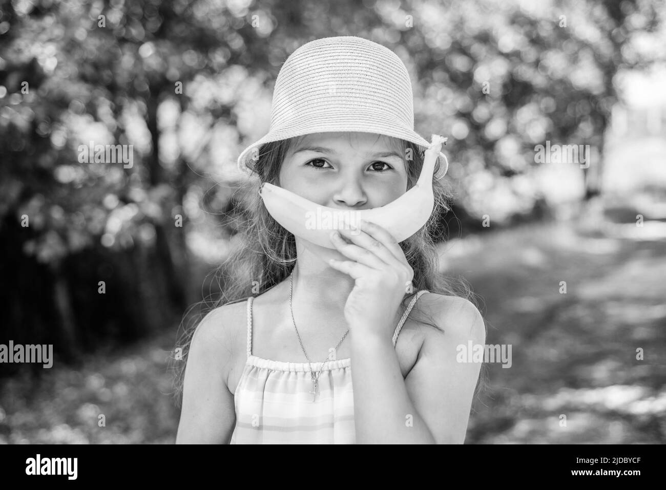 Banana sorriso. Divertente bambino su paesaggio naturale. Salute dei denti. Riempimento dei denti. Cura dentale. Igiene orale. Gengive sane. Odontoiatria pediatrica. Naturale Foto Stock